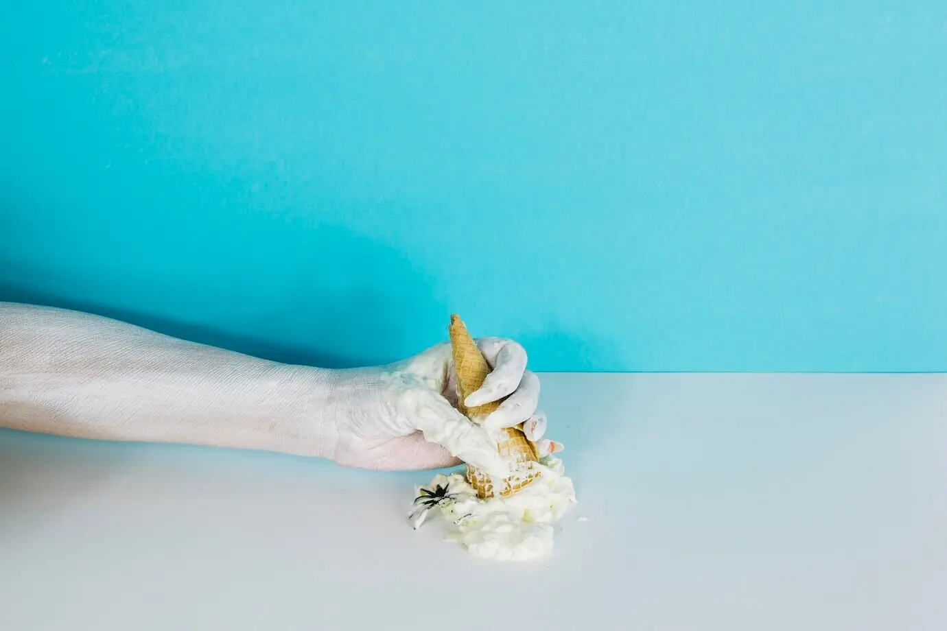 Blasse Hand zerdrückt Eiscreme