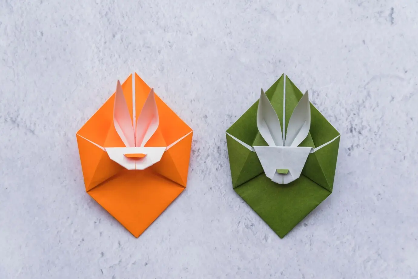 Origami in Form von grünen und orangefarbenen Kaninchen